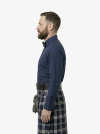 Man wearing a blue shirt and tartan kilt on a white background
