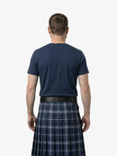 Man wearing a navy t-shirt and plaid kilt on a white background