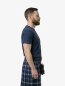 Man wearing a navy t-shirt and plaid kilt on a white background