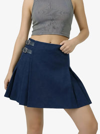 Person wearing a navy blue skirt with silver buckles on a white background
