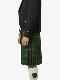 Person wearing a black jacket and green plaid kilt on a white background