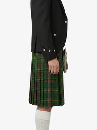 Person wearing a black jacket and green plaid kilt on a white background