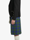 Person wearing a black jacket and a blue plaid kilt on a white background