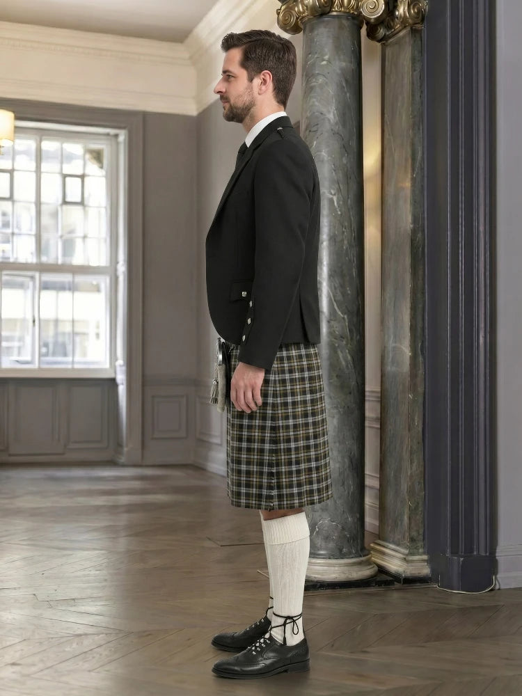 Man wearing a black jacket, plaid kilt, and white knee-high socks in an elegant room.