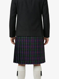 Person wearing a black coat and plaid kilt on a white background