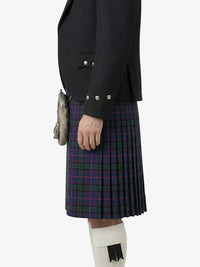 Person wearing a black jacket and tartan kilt on a white background