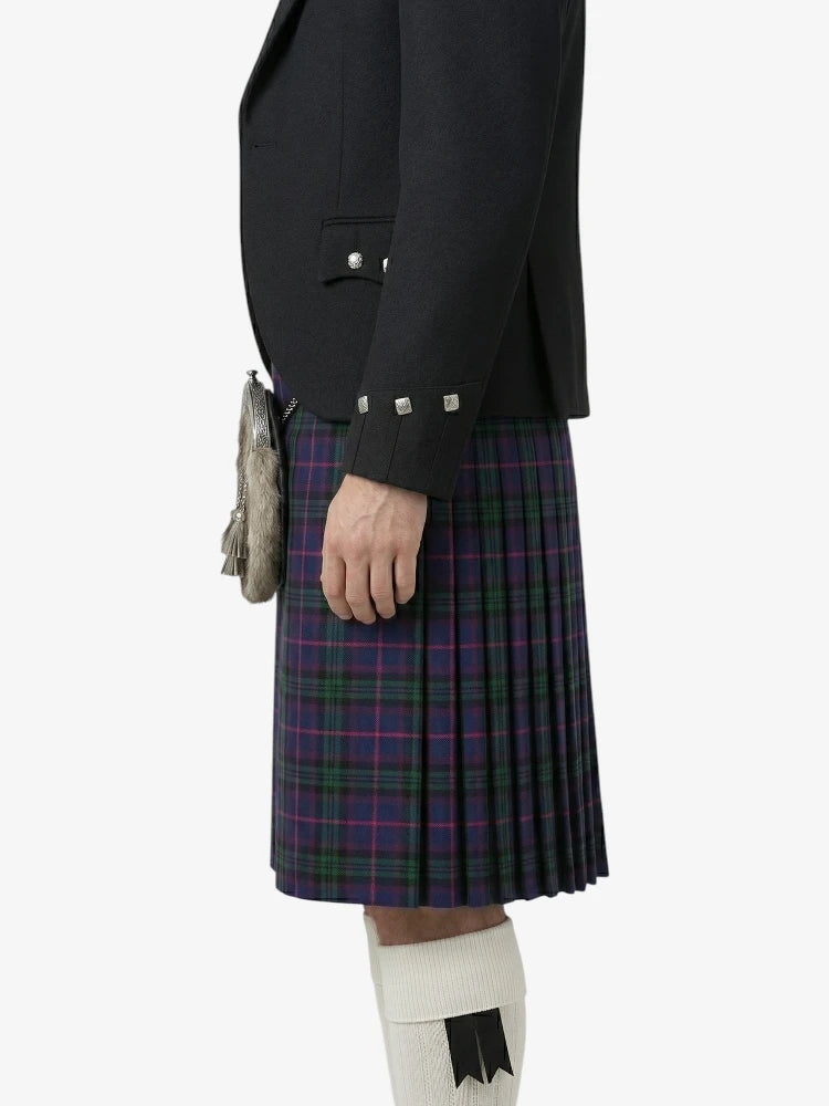 Person wearing a black jacket and tartan kilt on a white background
