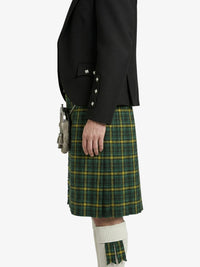Person wearing a black jacket and green plaid kilt on a white background