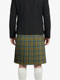 Person wearing a black jacket and green plaid kilt on a white background