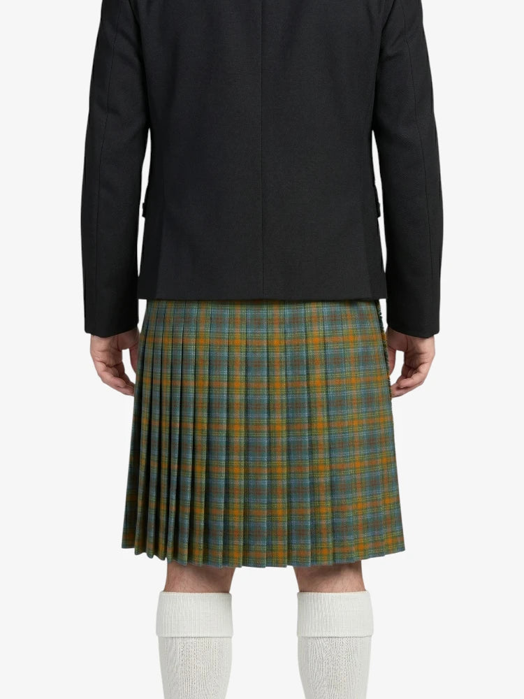 Person wearing a black jacket and green plaid kilt on a white background
