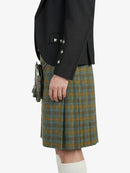 Person wearing a dark jacket and plaid kilt on a white background