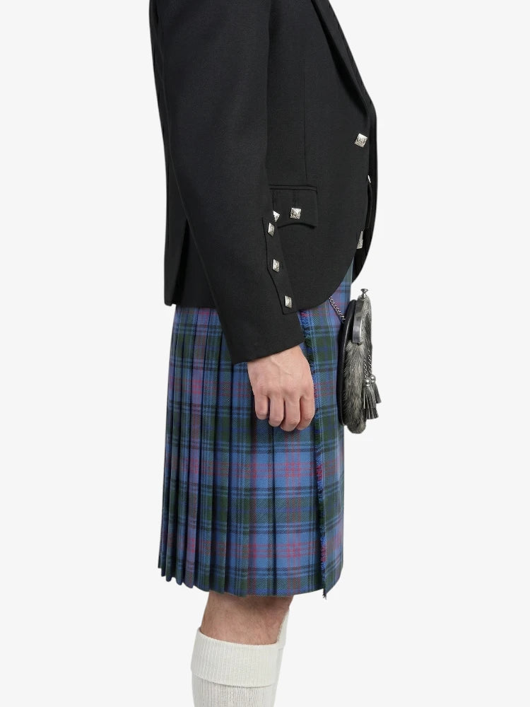 Person wearing a black blazer and plaid kilt on a white background
