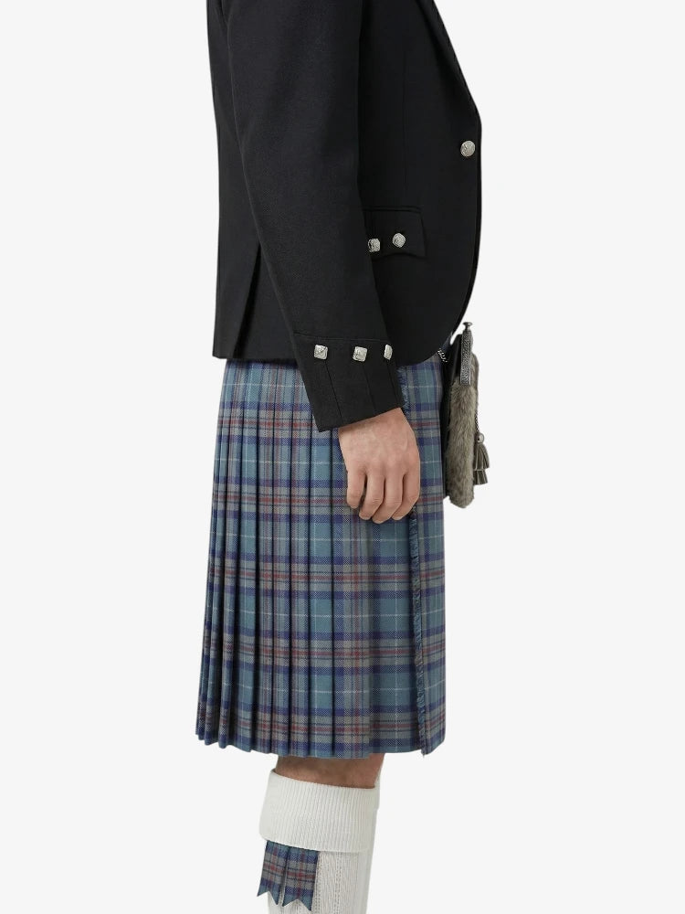 Person wearing a black jacket and plaid kilt on a white background