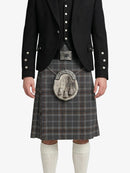 Person wearing a black jacket, gray plaid kilt, and white knee-high socks on a white background