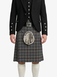 Person wearing a black jacket, gray plaid kilt, and white knee-high socks on a white background