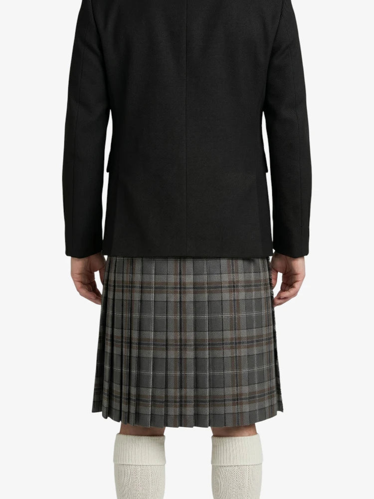 Person wearing a black jacket and plaid kilt on a white background