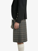 Person wearing a black blazer and plaid kilt on a white background