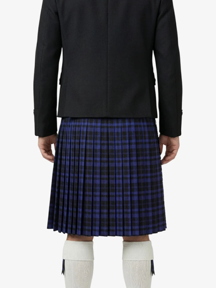 Person wearing a black jacket and blue plaid kilt on a white background