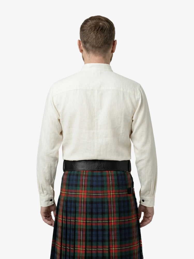 Man wearing a white shirt and a red, green, and blue plaid kilt on a white background