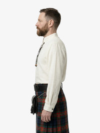 Man wearing a white shirt and tartan kilt on a white background