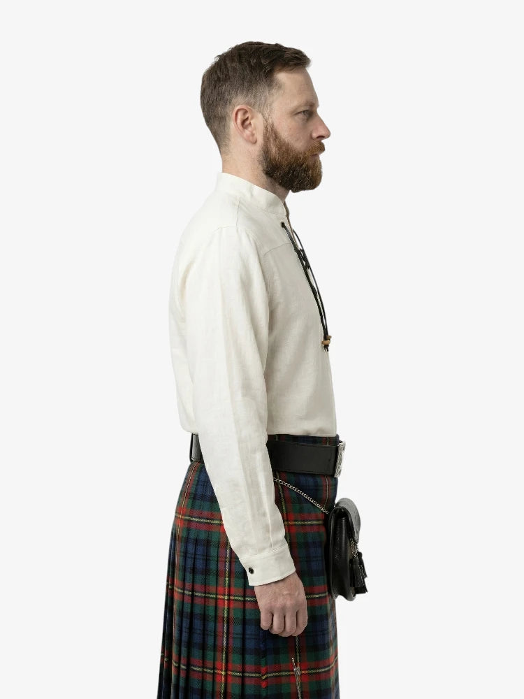Man wearing a white shirt and plaid kilt on a white background