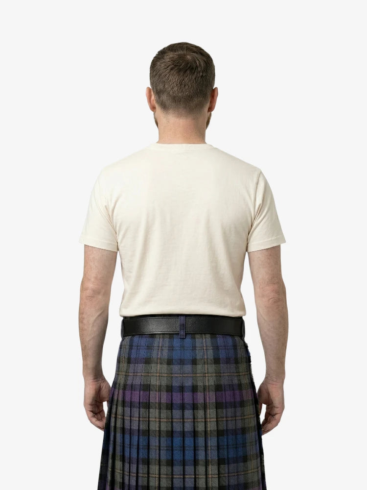 Man wearing a white t-shirt and a plaid kilt on a white background