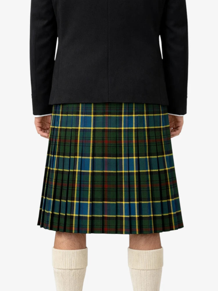 Person wearing a black jacket and green plaid kilt on a white background