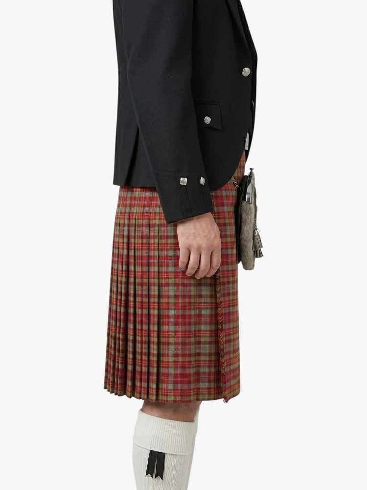 Person wearing a black jacket and red plaid kilt on a white background