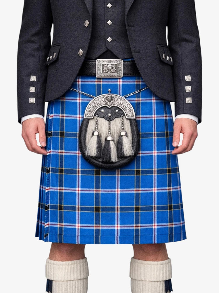 Person wearing a blue plaid kilt with a dark jacket and white socks on a white background