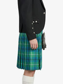Person wearing a black jacket and green plaid kilt on a white background