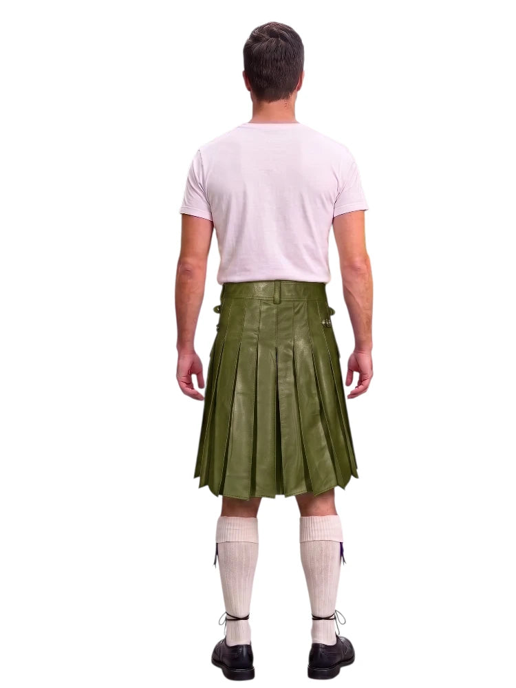 A man shown from the back wearing an olive green leather kilt, a light pink t-shirt, cream knee-high socks, and black shoes, against a solid white background.