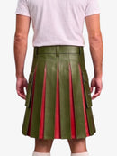 A model from the back wearing a pleated olive green faux leather kilt with red inner lining and side cargo pockets, paired with a light pink t-shirt.
