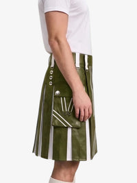 An olive green faux-leather kilt with vertical white stripes, silver-tone metal buttons, and a front flap pocket, shown on a model wearing a white t-shirt against a light gray background.