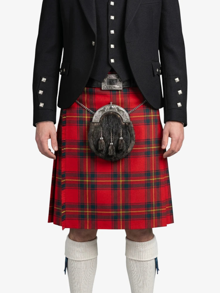 Person wearing a red plaid kilt with a black jacket on a white background