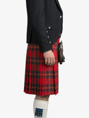 Person wearing a black jacket and red plaid kilt on a white background