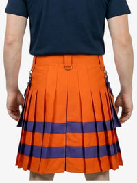 Person wearing an orange and blue pleated skirt with a navy shirt on a white background