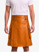 A model wearing a tan faux-leather kilt with silver-tone double-breasted buttons and side flap pockets, paired with a white t-shirt against a light gray background.