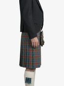 Person wearing a dark blazer and plaid kilt on a white background