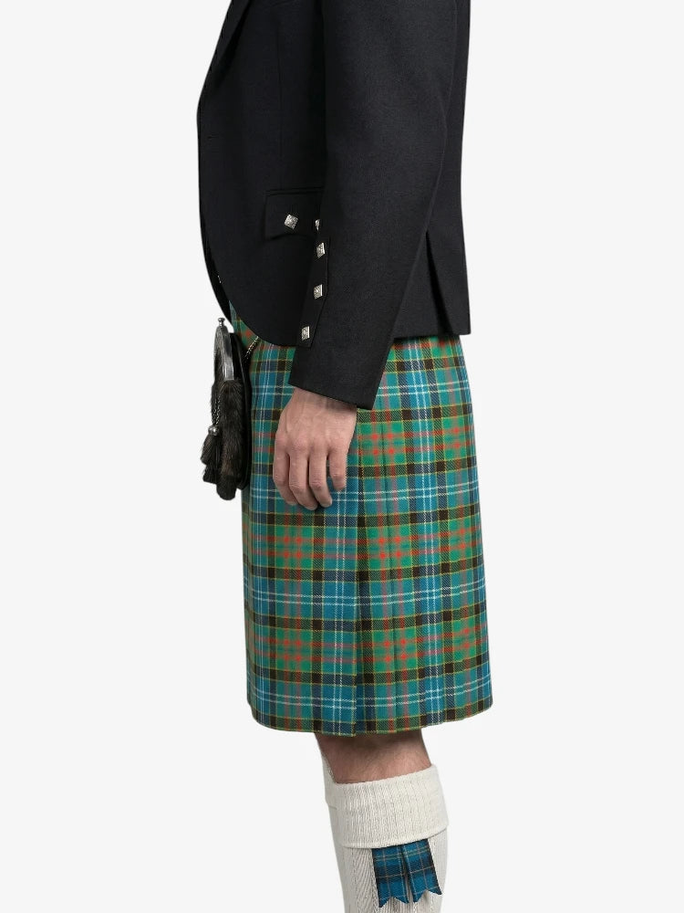 Person wearing a black jacket and green plaid kilt on a white background
