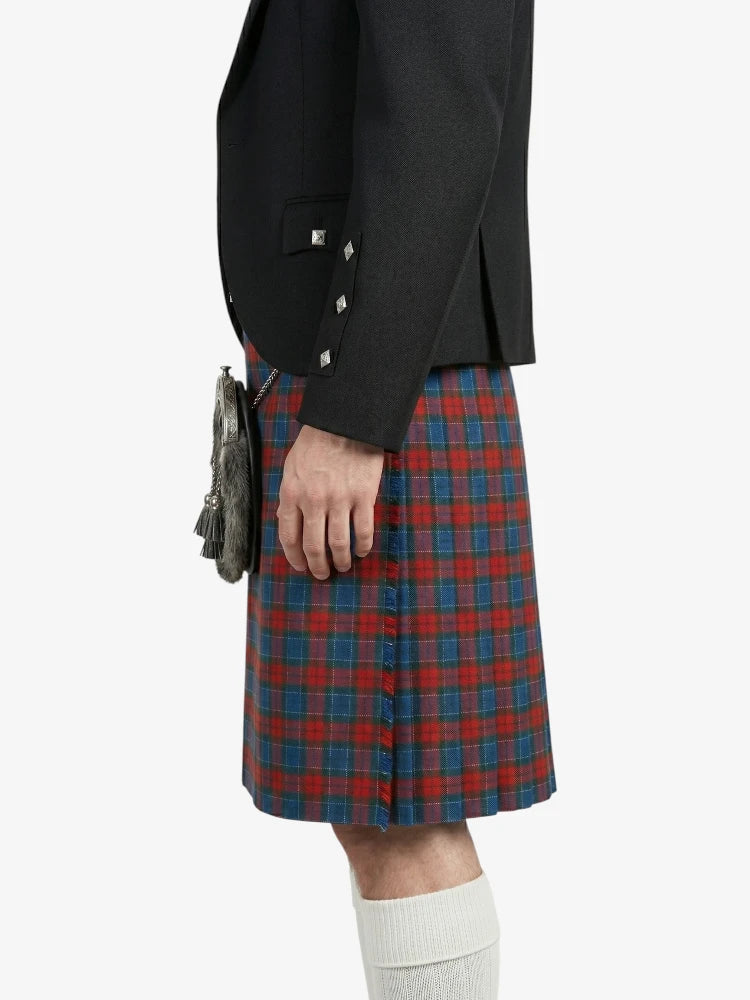 Person wearing a black blazer and red plaid kilt on a white background