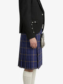 Person wearing a black blazer and blue plaid kilt on a white background