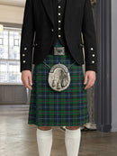 Person wearing a traditional Scottish kilt with a plaid pattern in a room with large windows.