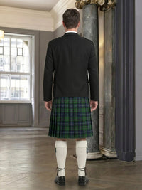 Man wearing a black jacket and green plaid kilt in an indoor setting.