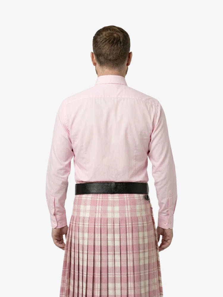 Man wearing a pink shirt and plaid skirt on a white background