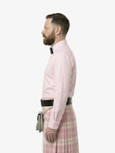 Man wearing a pink dress shirt and plaid skirt on a white background