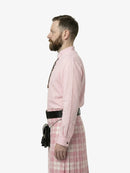 Man wearing a pink shirt and plaid kilt against a white background