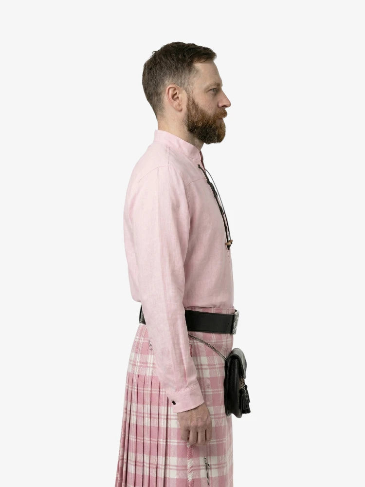 Man wearing a pink shirt and plaid skirt on a white background