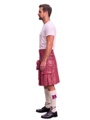 A man shown in profile wearing a pink leather kilt with a matching belt and pouch, a white t-shirt, white socks, and black shoes, against a plain white background.
