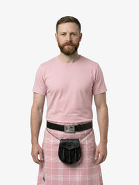 Man wearing a pink t-shirt and plaid kilt with a belt on a white background