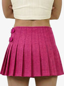 Pink pleated skirt worn by a person on a white background